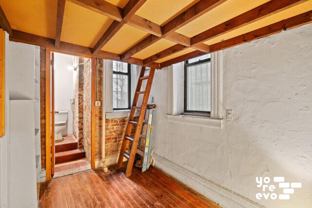 interior space with a textured wall and hardwood / wood-style flooring