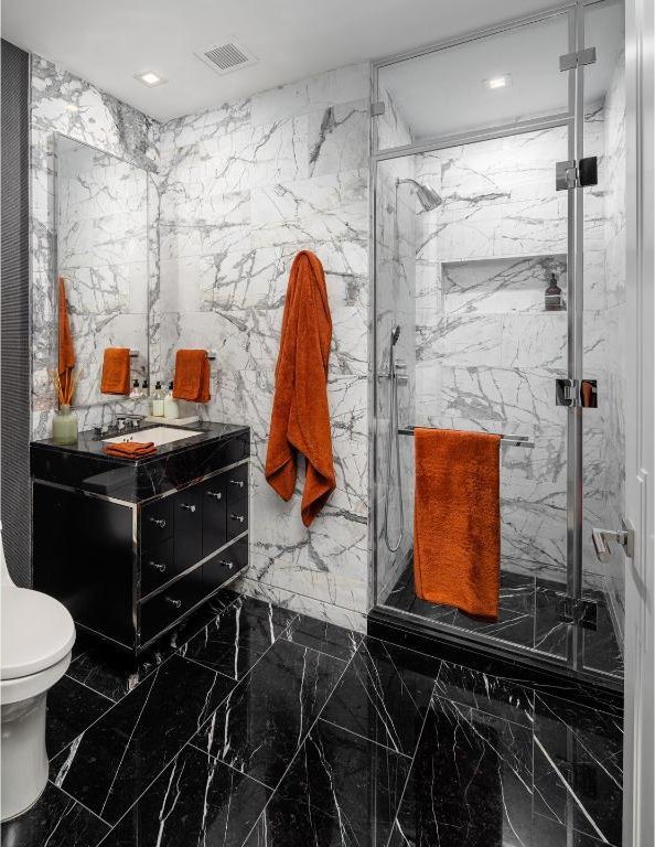 bathroom featuring walk in shower, vanity, and toilet