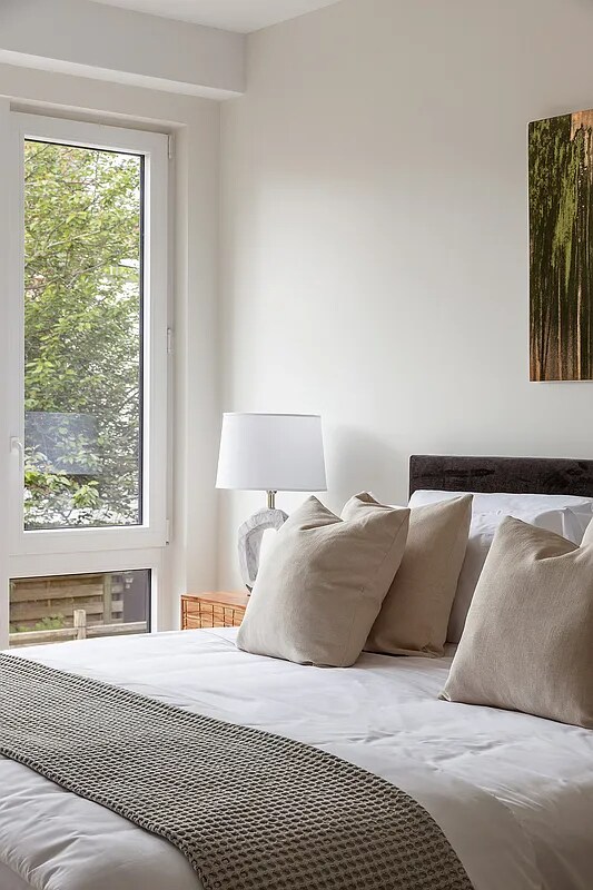 bedroom featuring light wood-type flooring and a wall mounted air conditioner