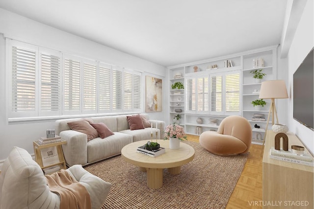 living room featuring built in shelves and light parquet floors