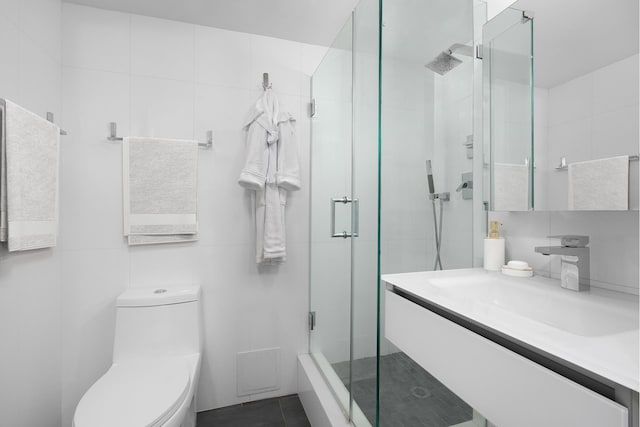 bathroom with a stall shower, tile walls, toilet, and vanity