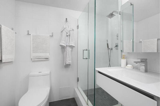 bathroom featuring a shower with door, vanity, and toilet