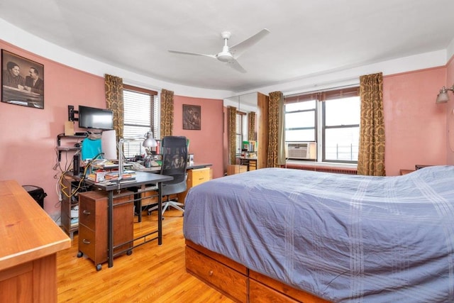 bedroom featuring ceiling fan, cooling unit, and light wood-type flooring