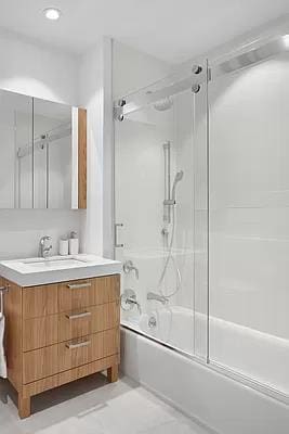 bathroom featuring vanity and shower / bath combination with glass door