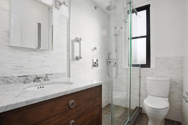 full bathroom with toilet, a shower stall, tile walls, and vanity