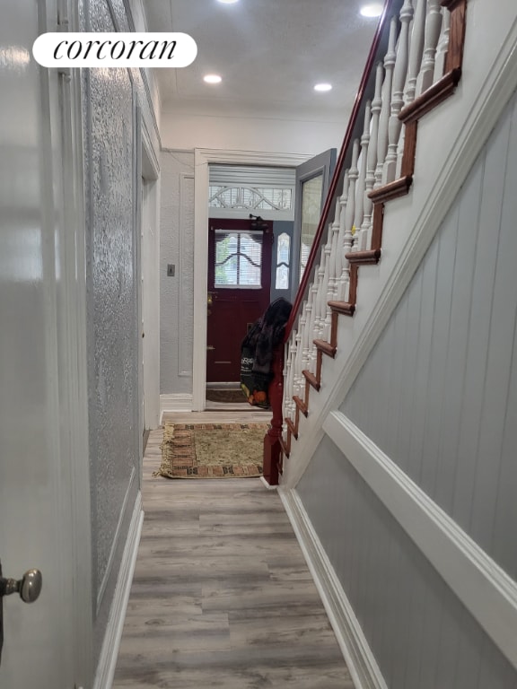 entryway with hardwood / wood-style floors and ornamental molding