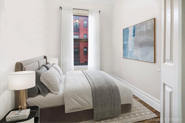 bedroom featuring baseboards and wood finished floors