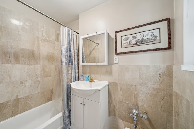 bathroom with vanity, tile walls, and shower / bathtub combination with curtain