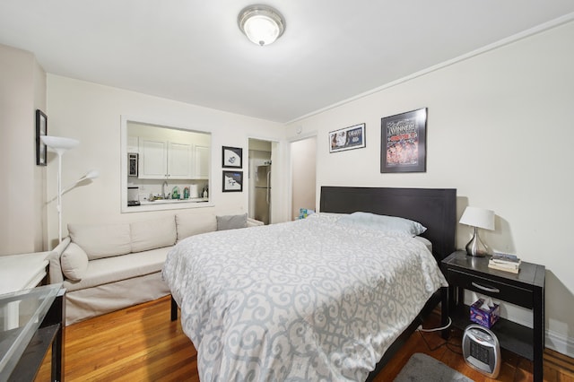 bedroom featuring stainless steel refrigerator and wood-type flooring