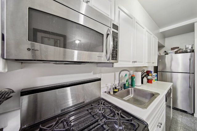 kitchen featuring stainless steel appliances, sink, and white cabinets