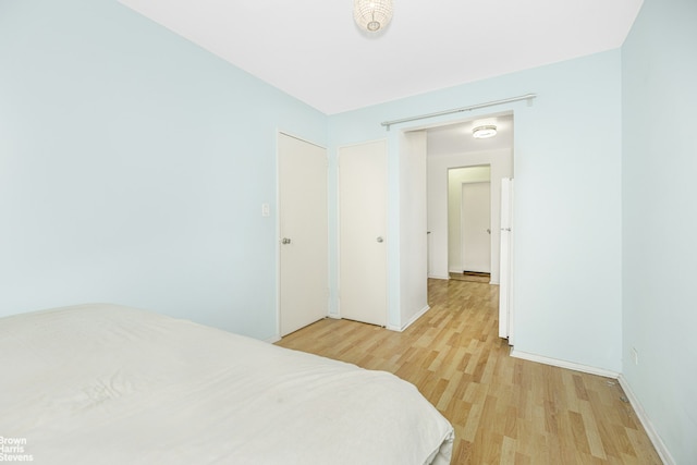 bedroom featuring light wood-style flooring and baseboards