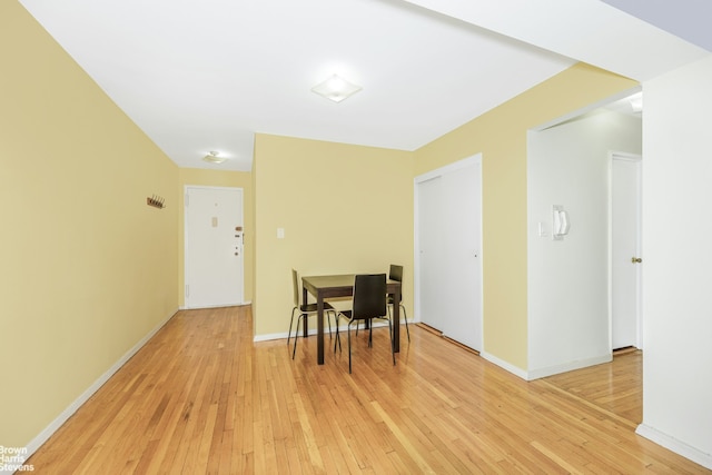 dining area featuring light wood finished floors and baseboards