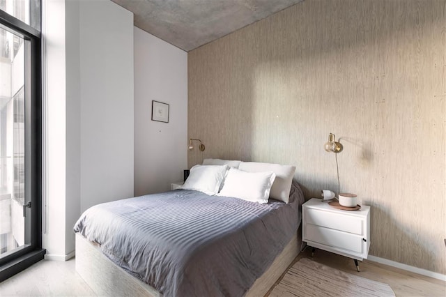 bedroom featuring baseboards and light wood-style floors