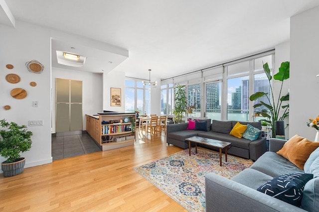 living room with a chandelier, floor to ceiling windows, and wood-type flooring