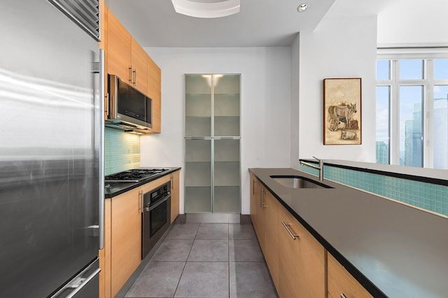 kitchen featuring light tile patterned floors, appliances with stainless steel finishes, and sink