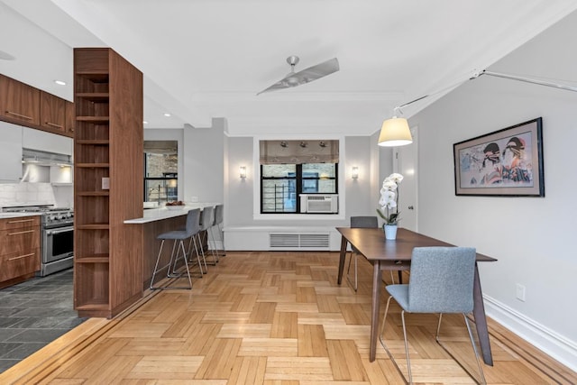 dining space featuring cooling unit and light parquet flooring