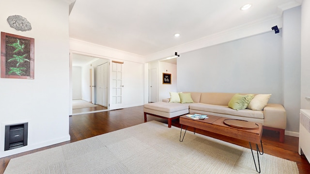 living room with wood finished floors, ornamental molding, radiator heating unit, recessed lighting, and baseboards