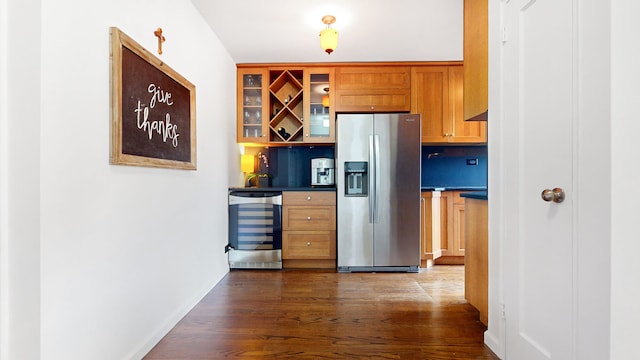 kitchen with stainless steel refrigerator with ice dispenser, wine cooler, dark wood-style floors, brown cabinets, and glass insert cabinets
