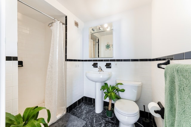 bathroom featuring toilet, a shower with shower curtain, tile walls, and sink