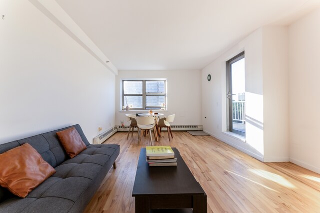 1831 Madison Ave Unit 9-F, New York City, NY 10035 - living area with wood finished floors, a baseboard heating unit, and baseboards