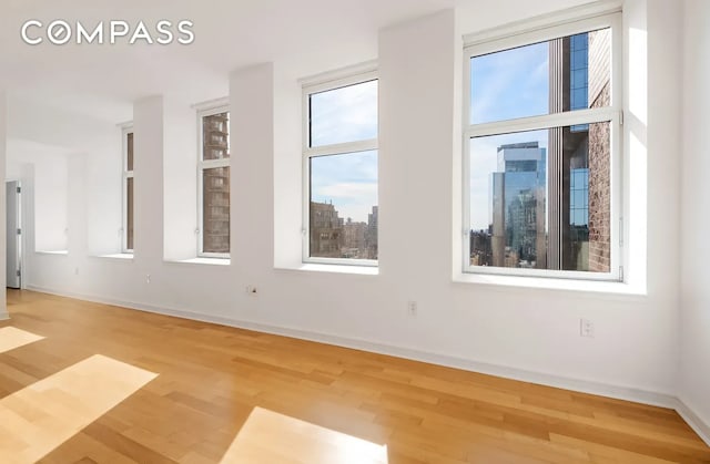 empty room featuring wood finished floors and baseboards