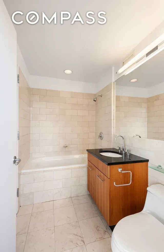 11 E 29th St Unit 28B, New York City, NY 10016 - bathroom with toilet, vanity, marble look tiles, and recessed lighting