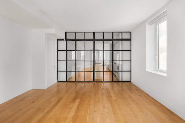 empty room with hardwood / wood-style floors and baseboards