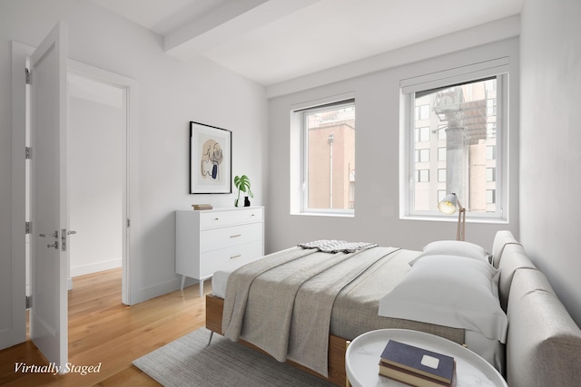 bedroom with light wood finished floors, multiple windows, and baseboards