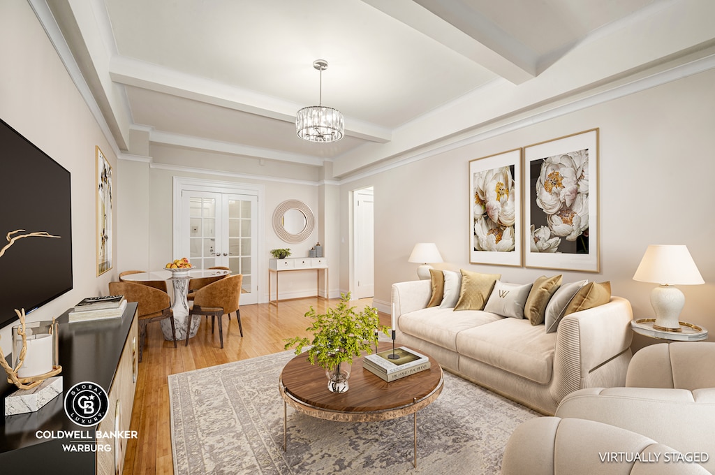 living room with beam ceiling, a chandelier, light wood finished floors, and french doors