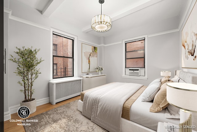 bedroom featuring cooling unit, radiator, wood-type flooring, and beamed ceiling