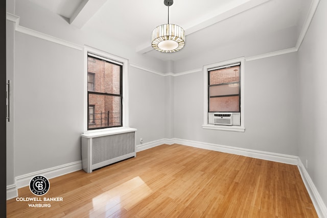 unfurnished room with cooling unit, radiator, wood-type flooring, and beamed ceiling