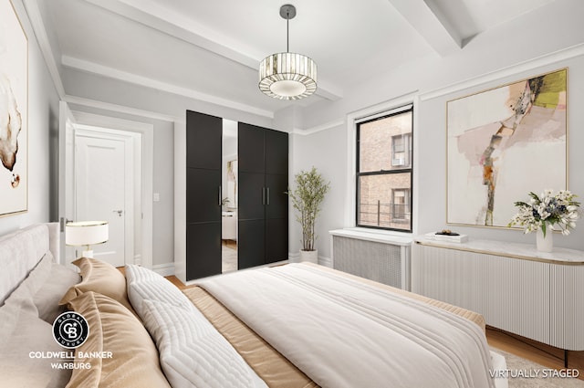 bedroom with beam ceiling, radiator, and light wood-type flooring