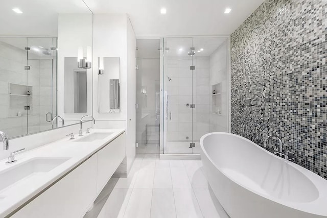 full bath featuring a freestanding tub, a sink, tile walls, tile patterned floors, and a stall shower