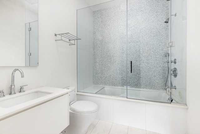 bathroom featuring bath / shower combo with glass door, tile patterned flooring, vanity, and toilet