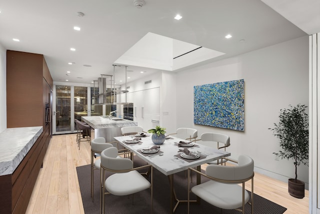 dining area with light wood-style floors and recessed lighting