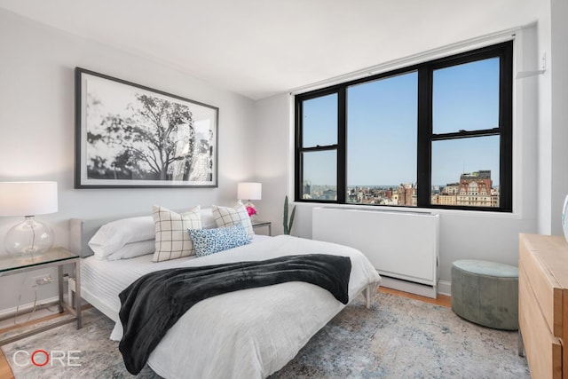 bedroom featuring hardwood / wood-style floors and radiator heating unit