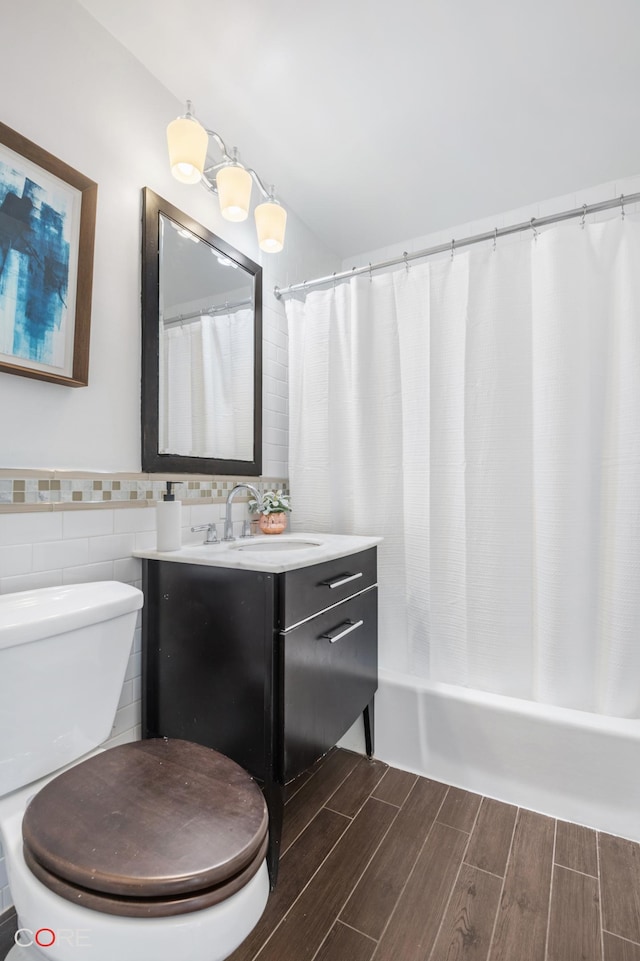 bathroom with toilet, tile walls, vanity, wood tiled floor, and shower / bath combo with shower curtain