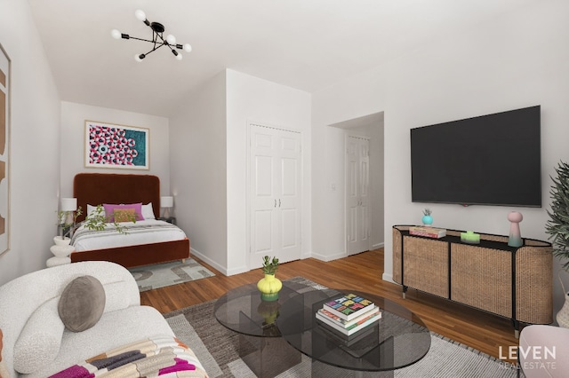 living area featuring a notable chandelier, wood finished floors, and baseboards