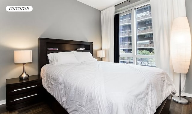 bedroom featuring multiple windows, wood finished floors, visible vents, and baseboards