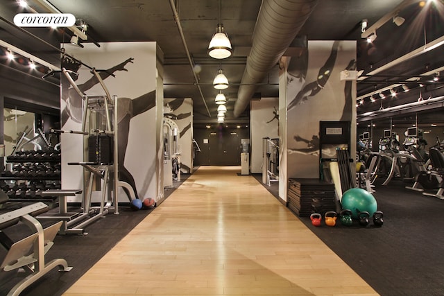 exercise room with wood-type flooring