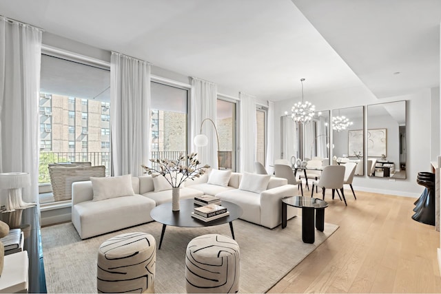 living area with a notable chandelier, baseboards, and wood finished floors