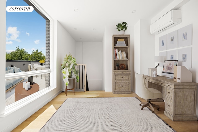 office space featuring light hardwood / wood-style flooring and an AC wall unit