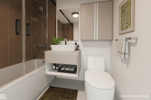 bathroom with combined bath / shower with glass door, toilet, vanity, and tile patterned flooring