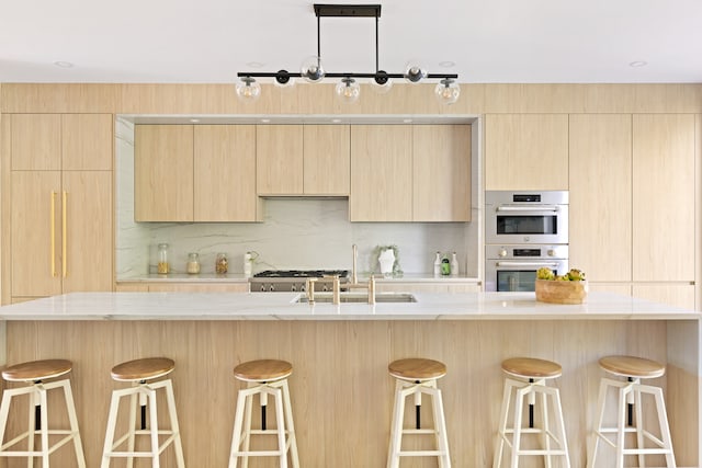 kitchen with backsplash, sink, a kitchen breakfast bar, light brown cabinets, and double oven