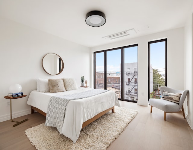 bedroom featuring light hardwood / wood-style flooring and access to outside