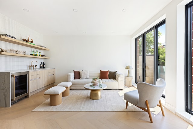 interior space with light parquet flooring, wet bar, and wine cooler