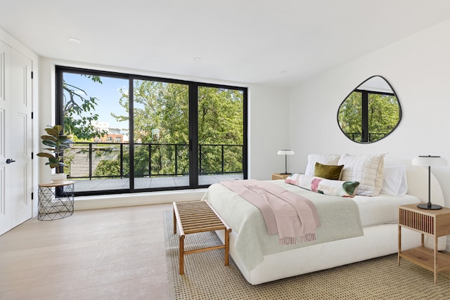 bedroom featuring expansive windows and light wood-type flooring