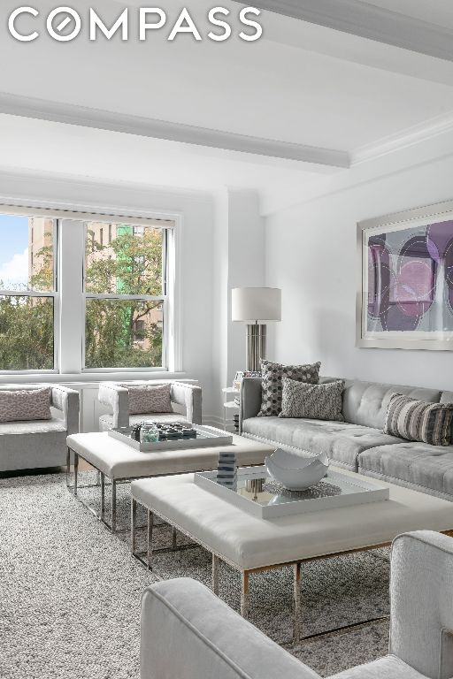 living room with crown molding and beam ceiling