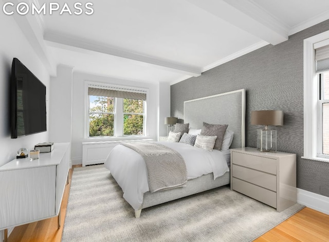 bedroom featuring light hardwood / wood-style floors, crown molding, and beamed ceiling