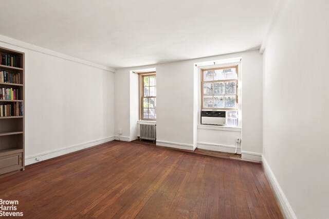 35 W 9th St Unit 1B, New York City, NY 10011 - unfurnished room with radiator heating unit, dark wood-style flooring, baseboards, and cooling unit